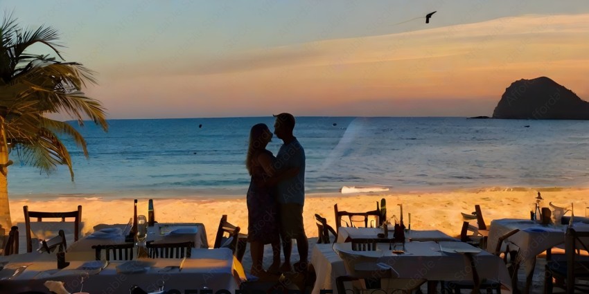 A couple kissing on a beach with a sunset in the background