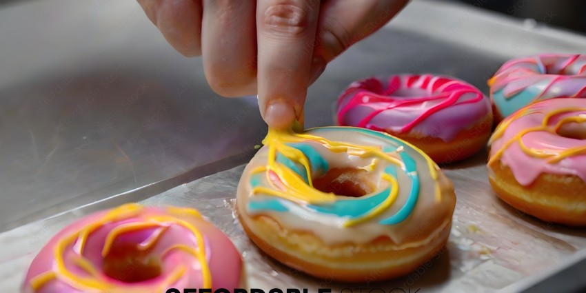 A person is decorating a donut with icing
