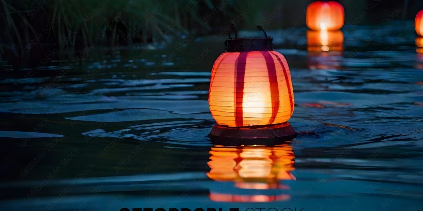 A red lantern with a black base sits in a body of water