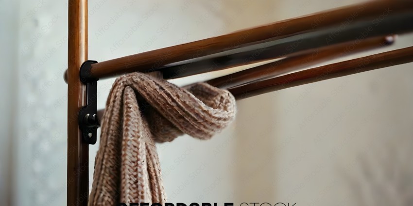 A brown woolen item hangs from a wooden bar