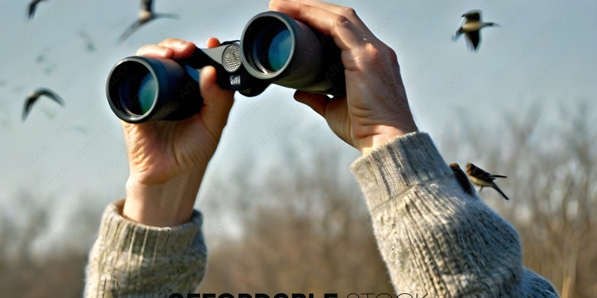 A person holding a pair of binoculars looking at something