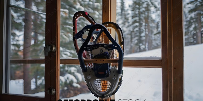 A snowboarding helmet hanging on a window