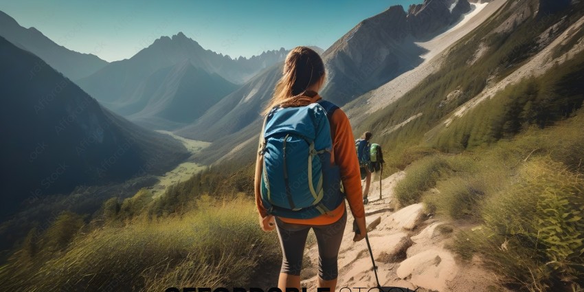 A woman wearing a blue backpack is walking on a mountain trail