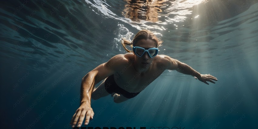 Man in blue goggles swimming underwater
