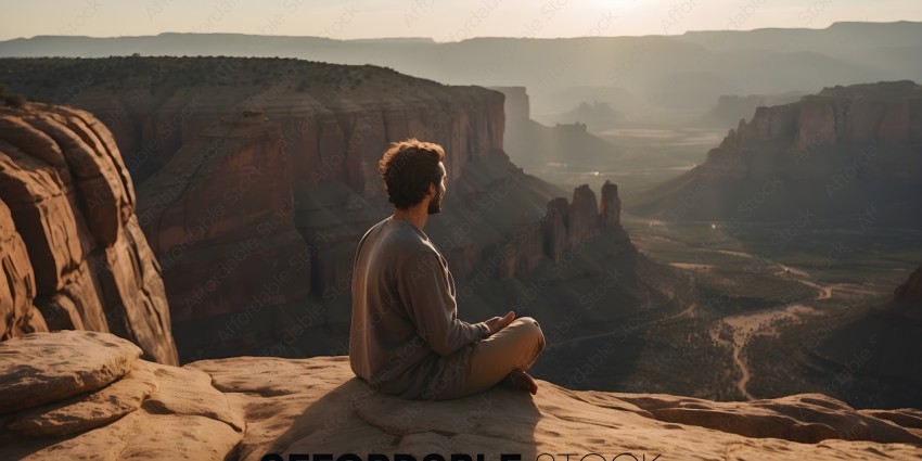 A man sitting on a rock overlooking a beautiful landscape