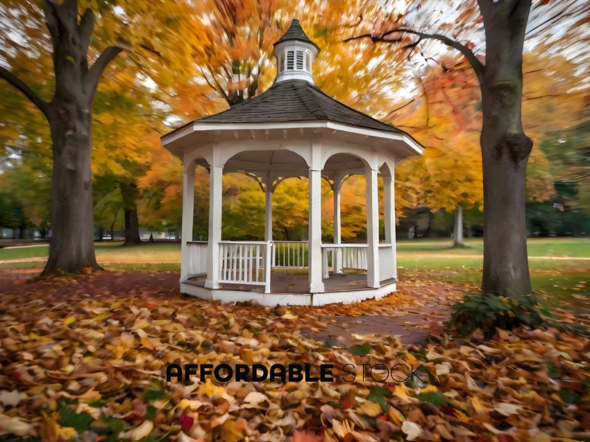 A gazebo in a park with autumn leaves