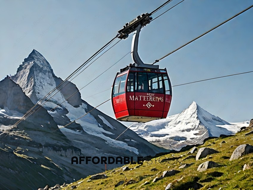A red gondola carries passengers over a mountain range
