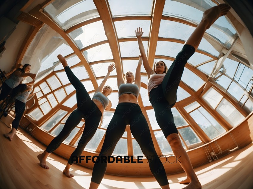 Three women in yoga poses in a glass room