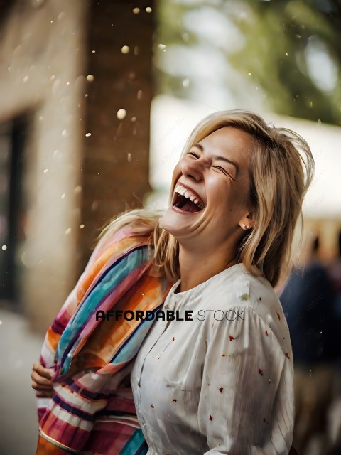 A woman laughing while holding a colorful towel