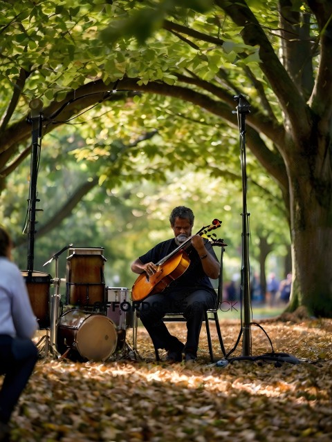 A man playing a small guitar in a park