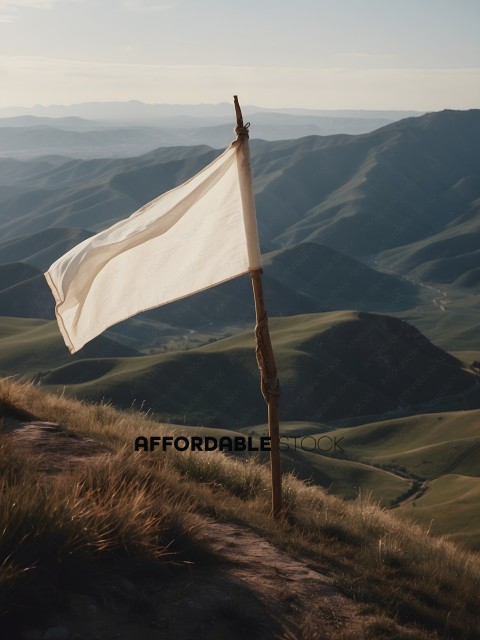 A white flag on a wooden pole in a mountainous area