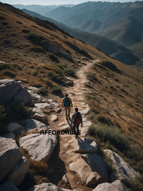 Two Hikers Walking Along a Path in the Mountains