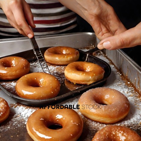 A person is cutting donuts with a spatula
