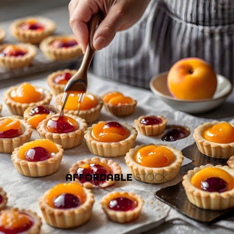 A person is putting a spoonful of jam into a pastry