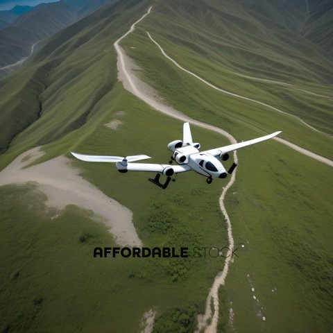A small white airplane flying over a green mountain
